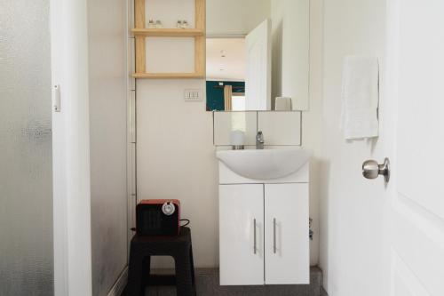 a white bathroom with a sink and a stool at Lodge del Maipo in San José de Maipo