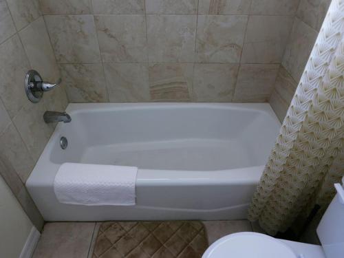 a white bath tub in a bathroom with a toilet at Cozy Beach Getaway in Cape Canaveral