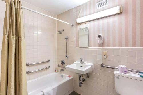 a bathroom with a sink and a tub and a toilet at Lotus by Hotel Inn in Boise
