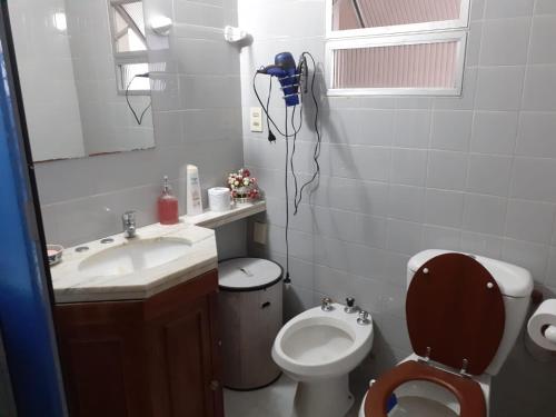 a bathroom with a sink and a toilet and a mirror at Los Naranjeles Centro Flat in Salto