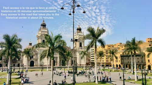 a large building with palm trees in front of it at ALU Apartments - Limit with Miraflores Panoramic City View in Lima
