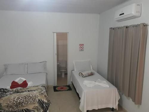 Habitación con 2 camas y lavabo. en pousada jalapão arco iris, en Mateiros