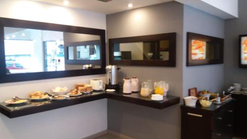 a room with a counter with food and mirrors at Urbano Hotel in Montevideo