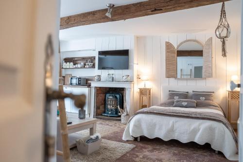 1 dormitorio con 1 cama y chimenea en LE ROMANTICA - Les Suites Romantiques Honfleur en Honfleur