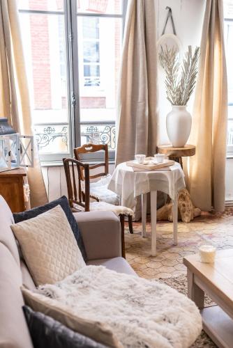 un salon avec un canapé et une table dans l'établissement LE ROMANTICA - Les Suites Romantiques Honfleur, à Honfleur