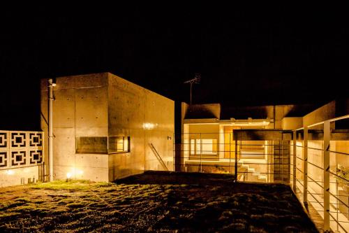 a building at night with the lights on at -Musée Villa- in Nakijin