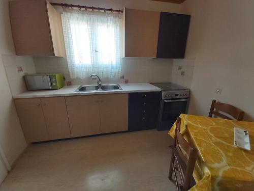 a kitchen with a sink and a stove at Eva Apartments in Svoronata