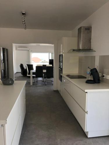 a kitchen with white cabinets and a living room at B. O. PARADIS SXM in Orient Bay