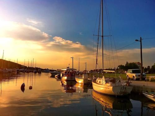 un grupo de barcos atracados en un puerto deportivo al atardecer en Apartment Neno - 100m from the sea en Sutomišćica