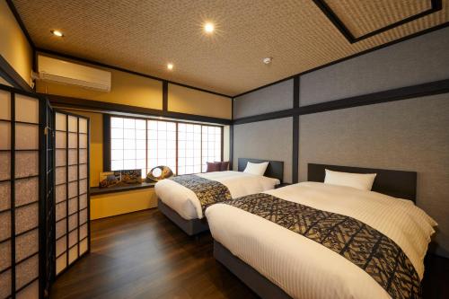 a hotel room with two beds and a window at Rinn Tsukinuke in Kyoto