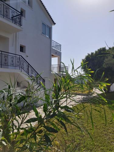 a white building with stairs leading up to it at Eva Apartments in Svoronata