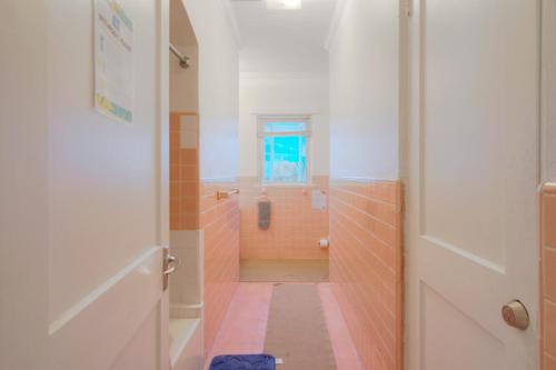 a bathroom with orange and white tile and a window at Hillcrest in Nassau