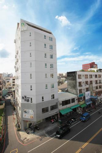 a tall white building on a city street at Green Hotel - Chiayi in Chiayi City