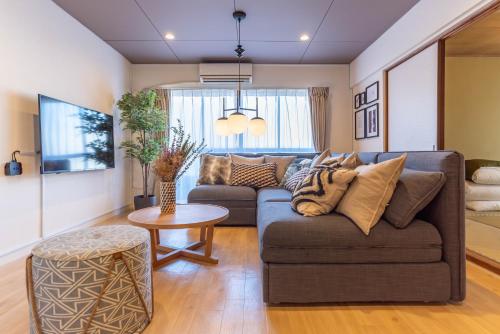 a living room with a couch and a table at Bijou Suites Pieces in Osaka