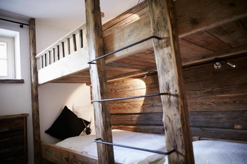 two bunk beds in a room with wooden walls at Auhäuslgut in Saalfelden am Steinernen Meer