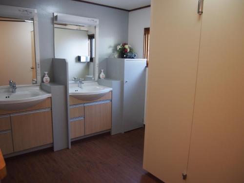 ein Badezimmer mit zwei Waschbecken und zwei Spiegeln in der Unterkunft Hagurokan in Tsuruoka
