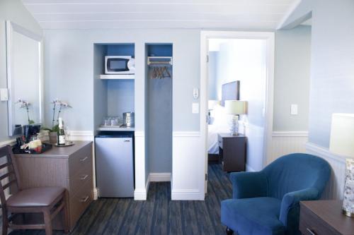 a living room with a blue chair and a bedroom at Ocean Echo Inn & Beach Cottages in Santa Cruz