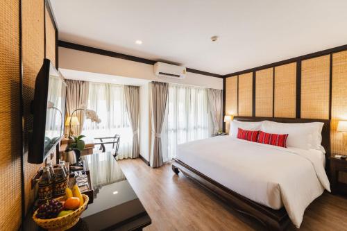 a bedroom with a large bed and a television at El Barrio Lanna in Chiang Mai