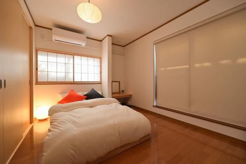 a bedroom with a bed and a large window at OMM STAY in Tokyo