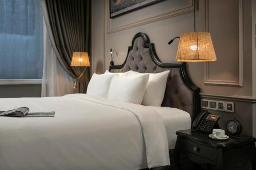 a hotel room with a bed and a telephone at Imperial Hotel & Spa in Hanoi