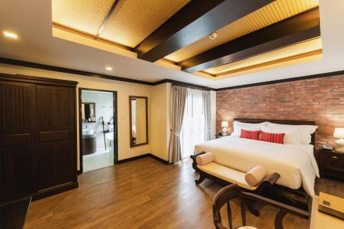 a bedroom with a bed and a brick wall at El Barrio Lanna in Chiang Mai