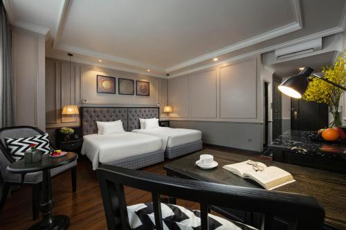 a hotel room with a bed and a desk and a table at Imperial Hotel & Spa in Hanoi