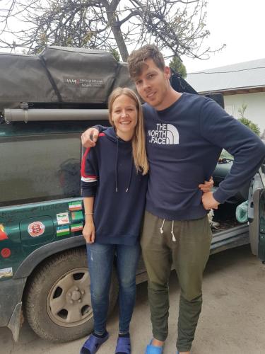 a man and a woman standing next to a truck at RAHAT Guest House & Hostel in Toktogul in Toktogul