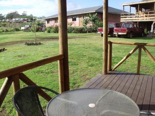 a table and chair on a porch with a truck at Cabañas Tokerau in Hanga Roa