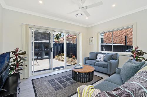 a living room with a couch and a table at Accommodation Hunter - Adams Street Maitland in Maitland