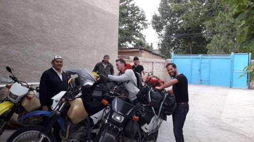 a group of men standing next to motorcycles at RAHAT Guest House & Hostel in Toktogul in Toktogul