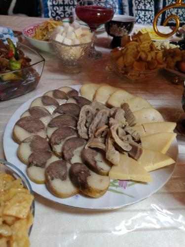 a plate of food with meat and apples on a table at RAHAT Guest House & Hostel in Toktogul in Toktogul