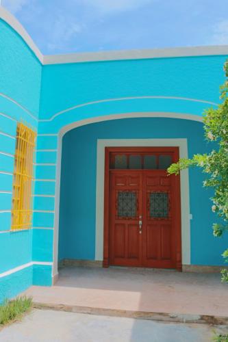 a blue building with a red door on it at Casa Dell´acqua Merida in Mérida