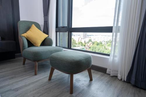 a chair with a yellow pillow sitting next to a window at SureStay Hotel by Best Western Vientiane in Vientiane