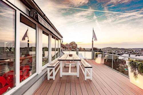 a wooden deck with a picnic table on a balcony at Architektenwohnungen mit Panoramablick bei Köln in Lindlar