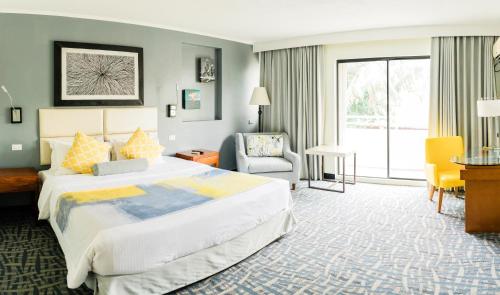 加拉班的住宿－世紀大酒店，酒店客房带一张大床和一把椅子
