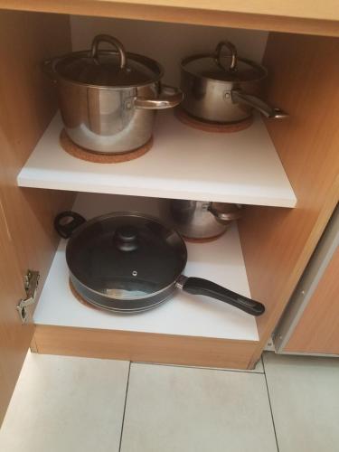 two pots and pans sitting on a shelf in a kitchen at Workers-Sleep-Station in Cologne