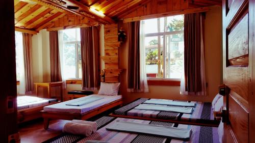 two beds in a room with two windows at Sagada Lodging Home in Sagada