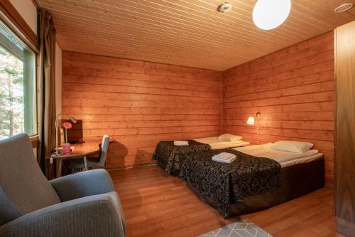 a room with two beds and a table and a chair at Poukama in Porvoo