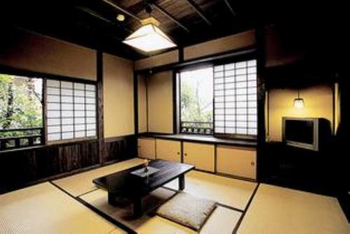 sala de estar con mesa y algunas ventanas en Syukubo Aso en Aso