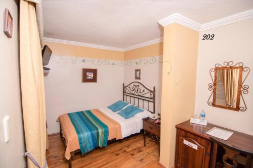 a small bedroom with a bed and a desk at Morenica del Rosario in Cuenca