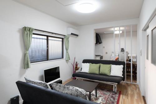 a living room with a couch and a table at Taro's House Kamakura Hase in Kamakura