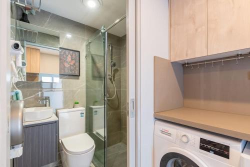 a bathroom with a toilet and a sink and a washing machine at Ensuite King Single Room - AC - Next to Central - Closely Located to Almost Sydney Must Seen Spots in Sydney