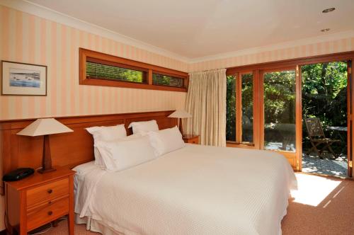 a bedroom with a white bed and a window at Lake Taupo Lodge in Taupo