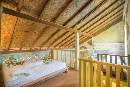 - une chambre avec un lit dans une pièce dotée d'un plafond en bois dans l'établissement ETHES Coworking - Coliving & Lounge, à Yogyakarta