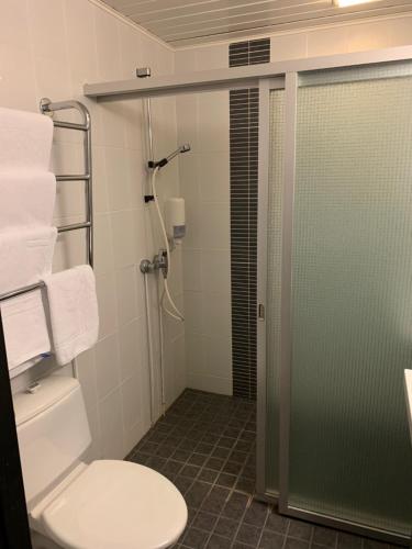 La salle de bains est pourvue de toilettes et d'une porte de douche en verre. dans l'établissement Kylpylähotelli Kiannon Kuohut, à Suomussalmi