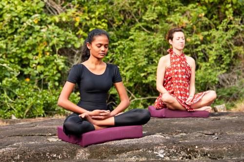 two women sitting on a rock in meditation at Amuna Ayurveda and Wellness Retreat in Sigiriya