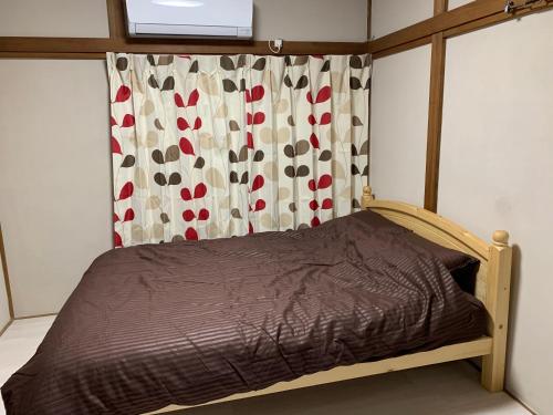 1 dormitorio con 1 cama con cortina y ventana en Vivian house en Tokio