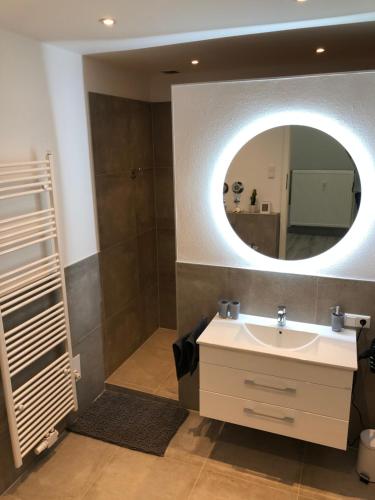 a bathroom with a sink and a mirror at Ermmes Ferienwohnungen in Sinsheim