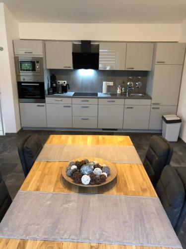 a kitchen with a table with a bowl of food on it at Ermmes Ferienwohnungen in Sinsheim