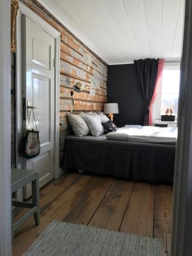 a bedroom with a bed and a brick wall at Pensionatet in Piteå